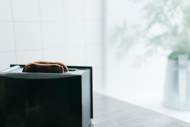 A close-up of freshly toasted bread popping from a sleek black toaster