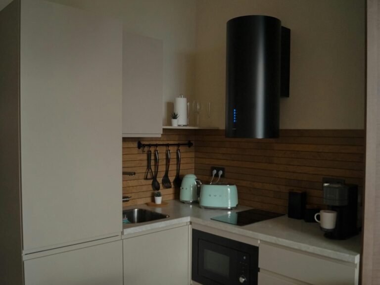 Stylish modern kitchen featuring sleek design with pastel appliances and wood accents.